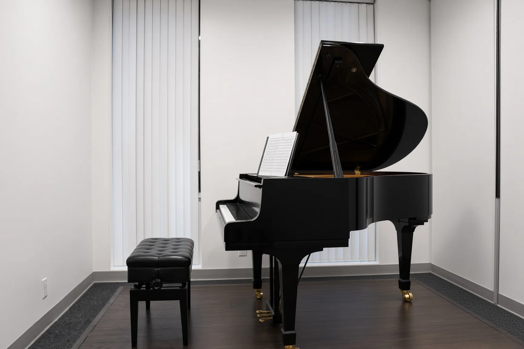 Grand piano and bench in an empty Issimo room