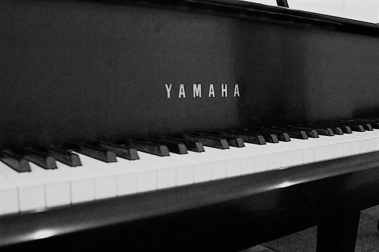 Yamaha lettering on a black grand fallboard, keys below